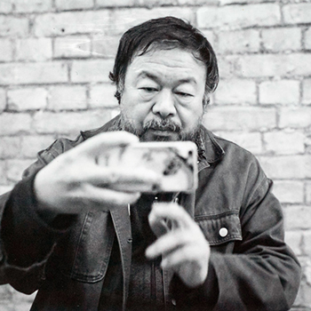 Chinese artist Ai Weiwei holding a phone to take a selfie