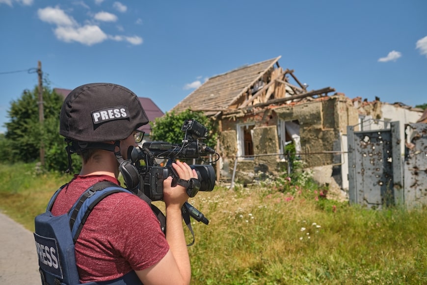 Ukrainian journalist filming in a village after it was freed from Russian occupation
